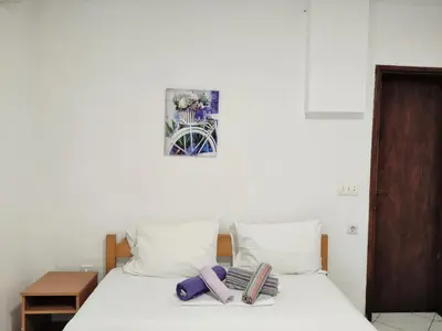 a bed with white sheets and purple towels on it at Guest House Violet in Becici