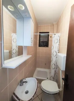 a bathroom with a sink and a toilet and a mirror at Guest House Violet in Becici