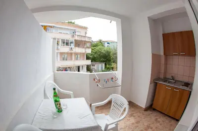 a small balcony with a table and chairs and a window at Guest House Violet in Becici