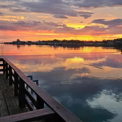 a sunset over a body of water with a dock at Sunset 4 in Ada