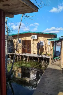 a man standing on a dock next to a house at Sunset 4 in Ada