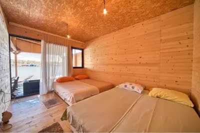 two beds in a room with a wooden wall at Sunset 4 in Ada