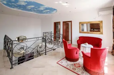 a living room with red chairs and a table at Villa Nuna in Bar