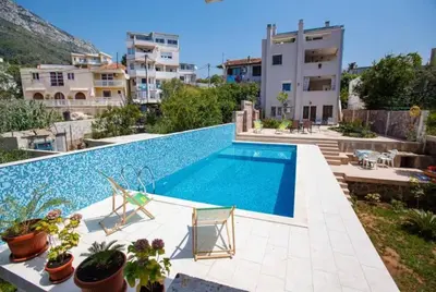 a swimming pool with two chairs and a building at Villa Nuna in Bar