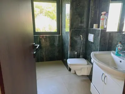 a bathroom with a toilet and a sink and a window at Villa Nuna in Bar