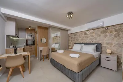a bedroom with a king sized bed and a kitchen at Apartments Račić in Kotor