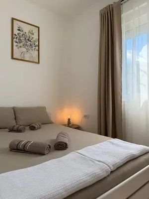 a bed with two pillows on it in a bedroom at Apartmani Stefanos - Jaz in Budva