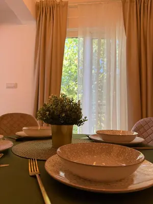a table with bowls and plates on it with a window at Apartmani Stefanos - Jaz in Budva