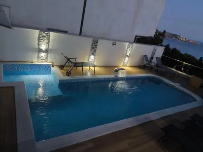 a large swimming pool with a table and lights at Vila Eden in Bar