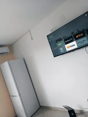 a kitchen with a refrigerator and a tv on the wall at Vila Eden in Bar
