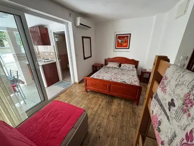 a small bedroom with a bed and a mirror at Apartments TRI SRCA in Sutomore