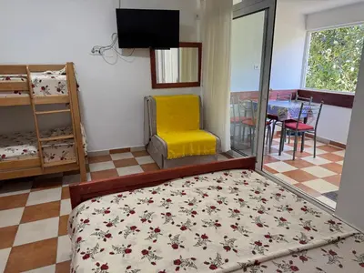 a bedroom with a bed and a yellow chair at Apartments TRI SRCA in Sutomore