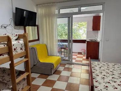a bedroom with a bed and a yellow chair in a room at Apartments TRI SRCA in Sutomore