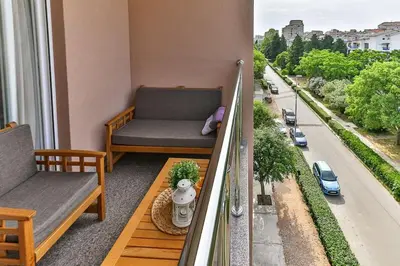 a balcony with a bench and a couch on a city street at Bar- Apartment Prestige in Bjeliši