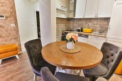 a kitchen with a wooden table with a vase of flowers at Bar- Apartment Prestige in Bjeliši