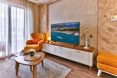 a living room with a television on a brick wall at Bar- Apartment Prestige in Bjeliši