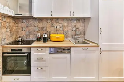 a kitchen with white cabinets and a yellow bowl on the counter at Bar- Apartment Prestige in Bjeliši