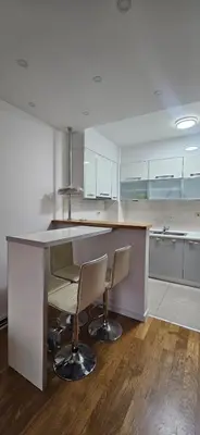 a kitchen with a counter and two chairs in it at Seaside Port Apartments in Bar