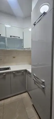 a kitchen with white cabinets and a refrigerator at Seaside Port Apartments in Bar