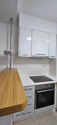 a kitchen with white cabinets and a stove top oven at Seaside Port Apartments in Bar