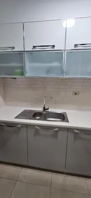 a kitchen counter with a sink and glass cabinets at Seaside Port Apartments in Bar