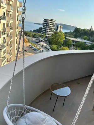 a swing on a balcony with a view of a city at Kuc-kuc Twin towers in Becici