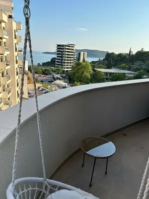 a chair on a balcony with a view of the city at Kuc-kuc Twin towers in Becici