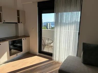 a living room with a sliding glass door to a balcony at Kuc-kuc Twin towers in Becici