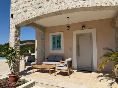 a patio with chairs and a table and a door at Villa Maluso in Budva