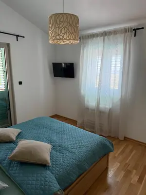 a bedroom with a bed with a blue comforter at Villa Maluso in Budva