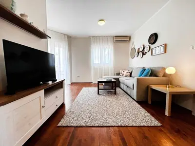 a living room with a couch and a flat screen tv at Stylish 1 Bedroom Apartment Budva in Budva
