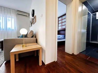 a living room with a couch and a table with a lamp at Stylish 1 Bedroom Apartment Budva in Budva