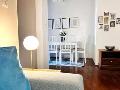 a living room with a white table and chairs at Stylish 1 Bedroom Apartment Budva in Budva