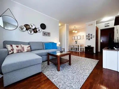 a living room with a blue couch and a table at Stylish 1 Bedroom Apartment Budva in Budva