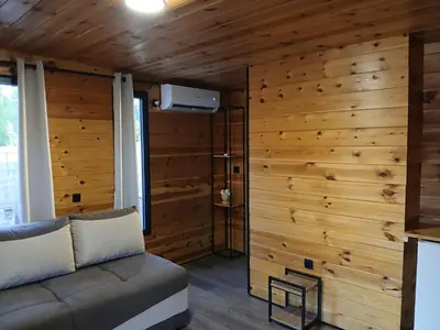 a living room with a couch and a wooden wall at Corner Bungalow in Ulcinj