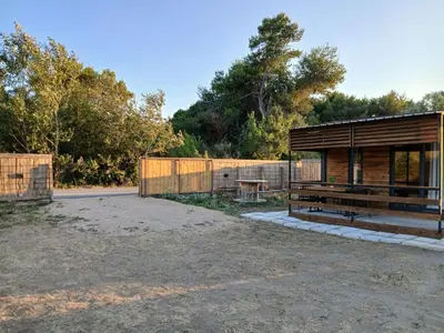 a building with a bench and a fence at Corner Bungalow in Ulcinj