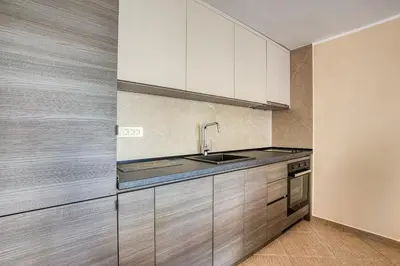 a kitchen with white cabinets and a sink at Spacious Comfort in Boreti