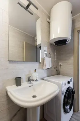 a bathroom with a sink and a washing machine at Spacious Comfort in Boreti