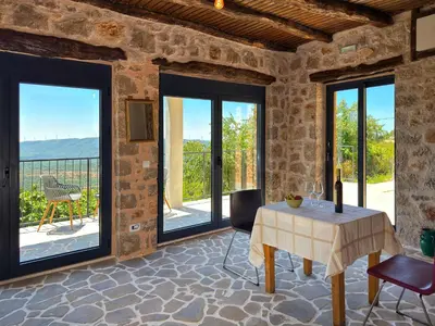 a living room with a table and glass doors at Villa Kula apartments in Bar