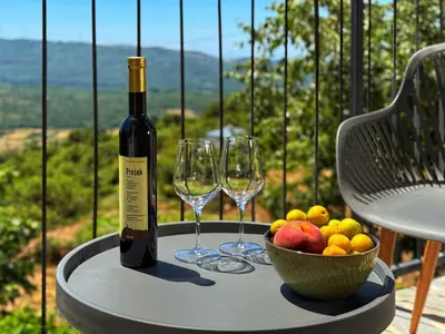 a table with two wine glasses and a bowl of fruit at Villa Kula apartments in Bar
