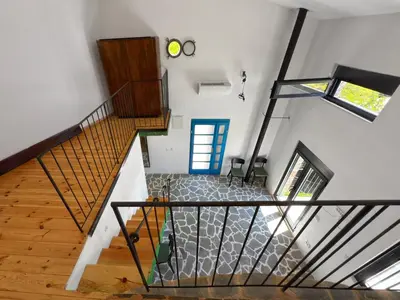 a spiral staircase in a house with a blue door at Villa Kula apartments in Bar