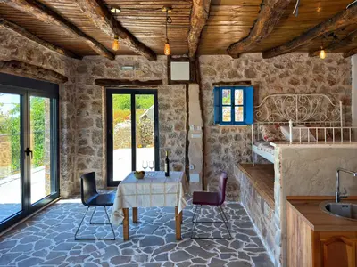a kitchen with a table and chairs in a room at Villa Kula apartments in Bar