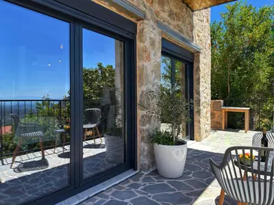 a sliding glass door with a patio with a table and chairs at Villa Kula apartments in Bar