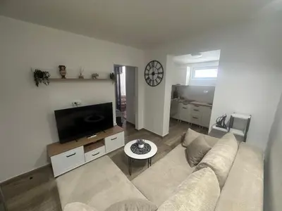 a living room with a couch and a flat screen tv at Cozy one bedroom apartment with parking in Petrovac na Moru