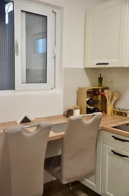 a kitchen with a wooden table and two chairs at Cozy one bedroom apartment with parking in Petrovac na Moru