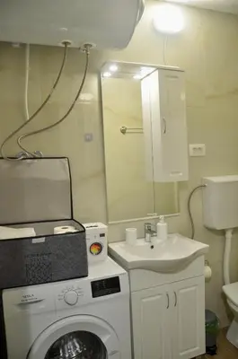 a bathroom with a washing machine and a sink at Cozy one bedroom apartment with parking in Petrovac na Moru