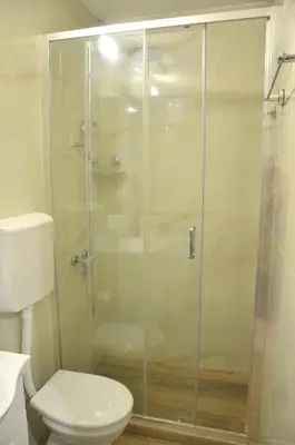a bathroom with a glass shower with a toilet at Cozy one bedroom apartment with parking in Petrovac na Moru