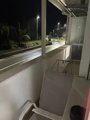 a chair sitting on a balcony at night at Njaro Del Mar AS in Petrovac na Moru
