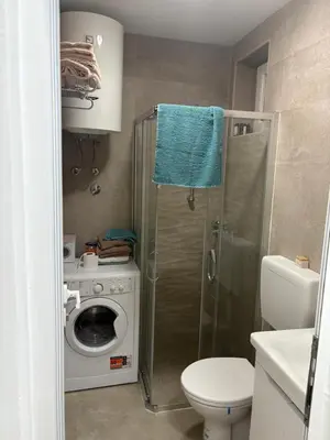a bathroom with a toilet and a washing machine at Njaro Del Mar AS in Petrovac na Moru