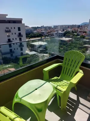two green chairs and a table on a balcony at Adriatic Glam in Bar